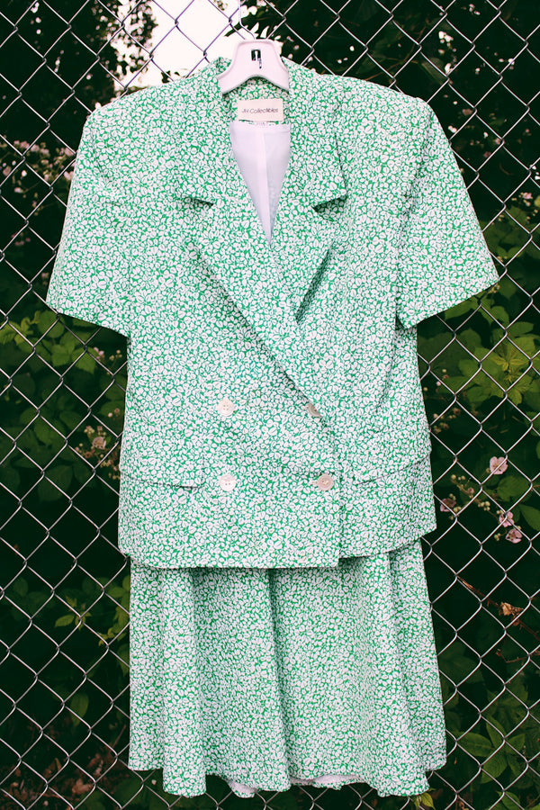 Women's vintage 1980's JH Collectibles, Made in USA label matching set in an all over green and white ditsy floral print. Short sleeve blazer jacket and midi skirt.