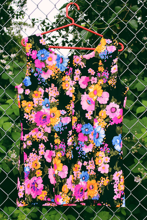 Women's vintage 1970's sleeveless tank top with a scoop neck and zipper closure in the back. Black with an all over multicolored floral print.