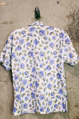 Women's vintage 1980's LORI by AM Casuals short sleeve button up blouse in white with all over blue floral print. Stretchy polyester material. 