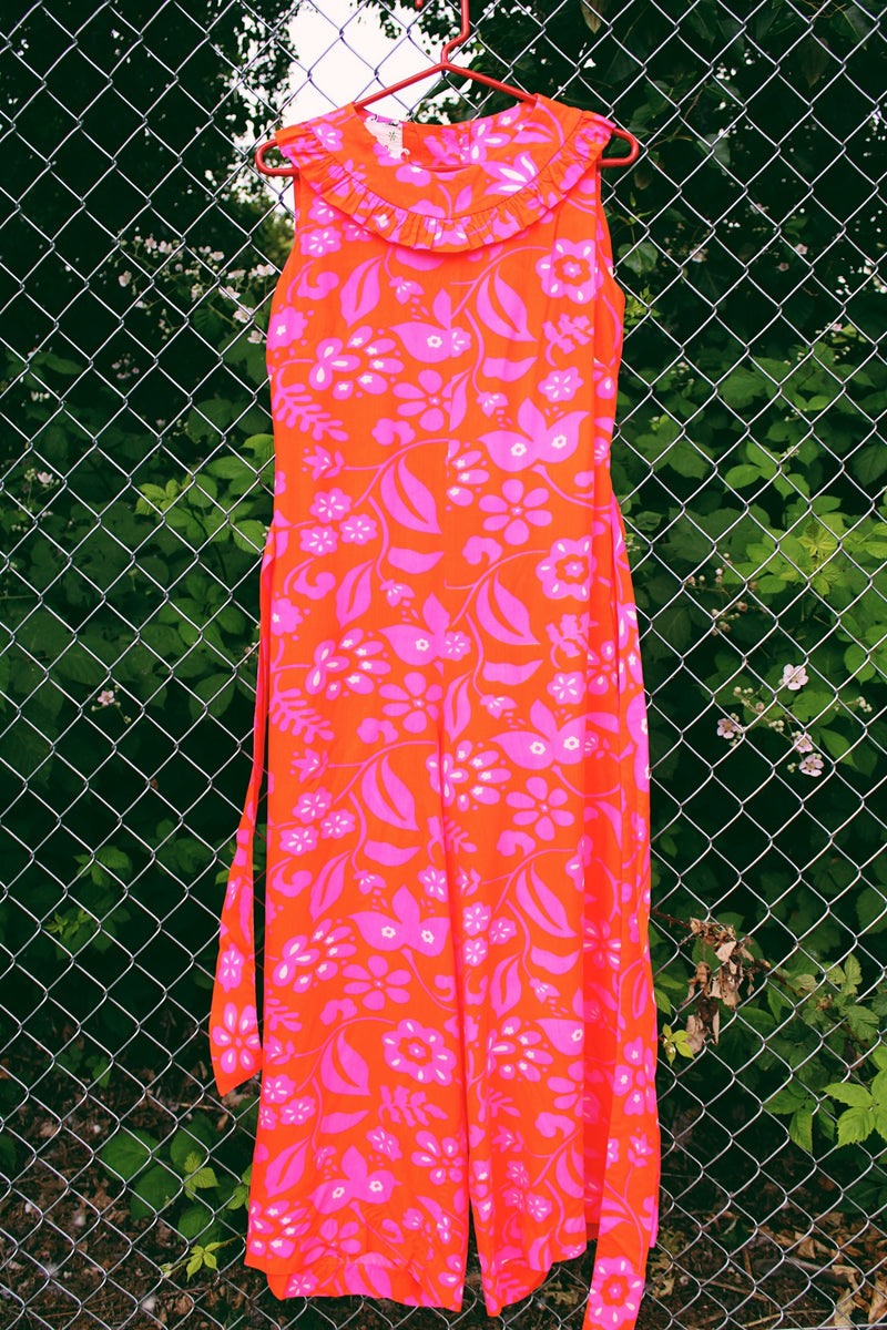 Women's vintage 1970's Liberty House for Lila Honolulu label sleeveless ankle length jumpsuit in a vibrant pink and orange Hawaiian print.