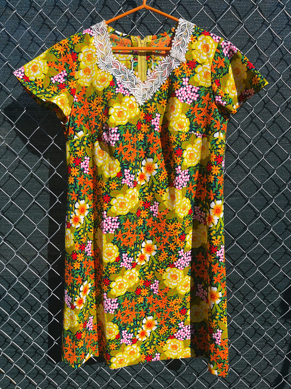 Women's vintage 1970's short sleeve mini length multicolored floral printed dress in polyester with lace trim collar. 
