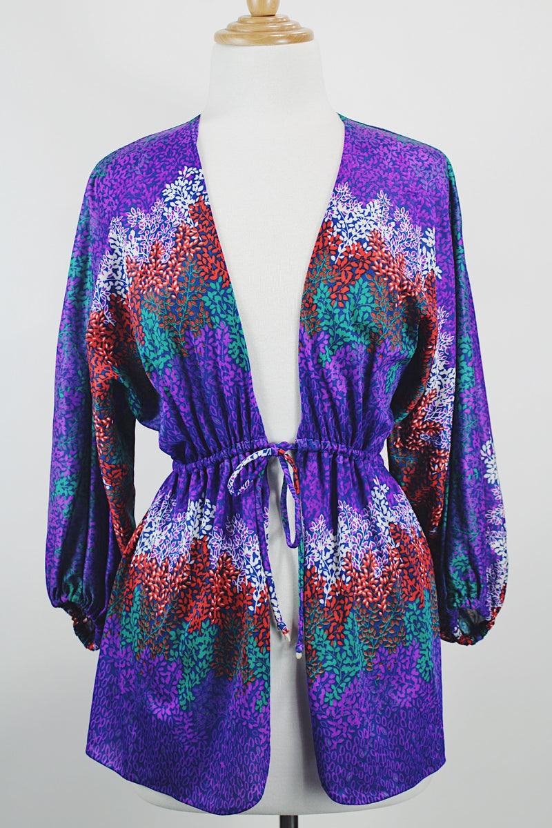Women's vintage 1970's Cole of California label tie front blouse with balloon sleeves in purple, green, and orange colors and a lightweight polyester material.