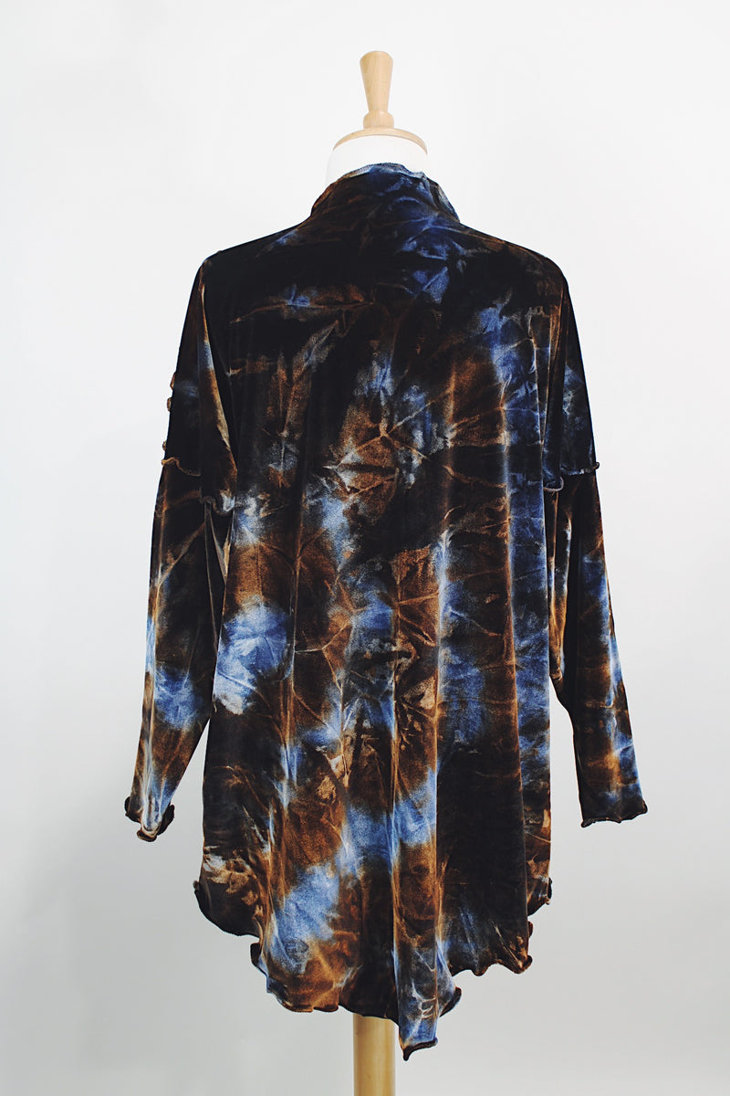 Long sleeve long length tie dye velvet top with a mock neck in a stretchy velvet material. Blue and brown colors with curly trim throughout.