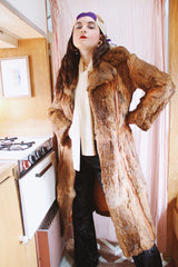 Women's vintage 1960's Apropos, Made in Korea label long sleeve knee length genuine fur coat with burnt orange leather trim and a tie belt.