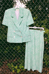 Women's vintage 1980's JH Collectibles, Made in USA label matching set in an all over green and white ditsy floral print. Short sleeve blazer jacket and midi skirt.