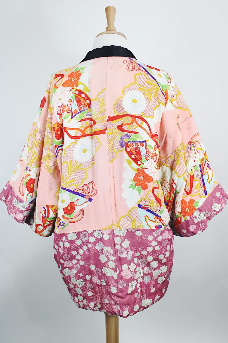 Women's vintage 1970's long sleeve puffy kimono jacket with all over multicolored patchwork print. Open front and square shaped arms.