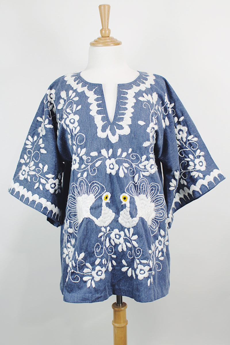Women's vintage 1970's blue chambray tunic blouse with flared sleeves and a V shaped neckline. Has a white embroidered bird on the front.