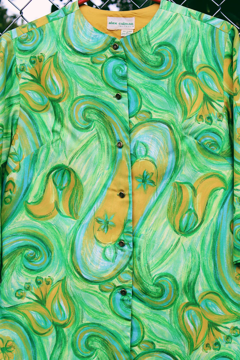 Women's vintage 1970's Alex Colman California label 3/4 arm length button up smock blouse in a vibrant green abstract print. Brass buttons and side slits. 