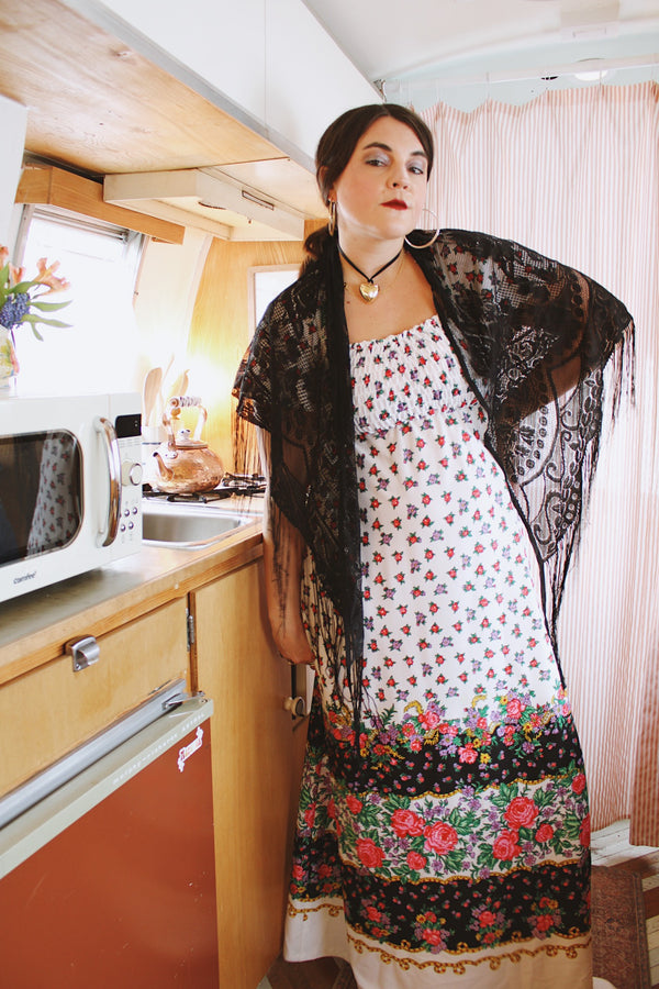 1970's vintage black lace triangle scarf with long fringe trim that can be worn as a shawl. Shop more vintage accessories at Live Forever Vintage. 