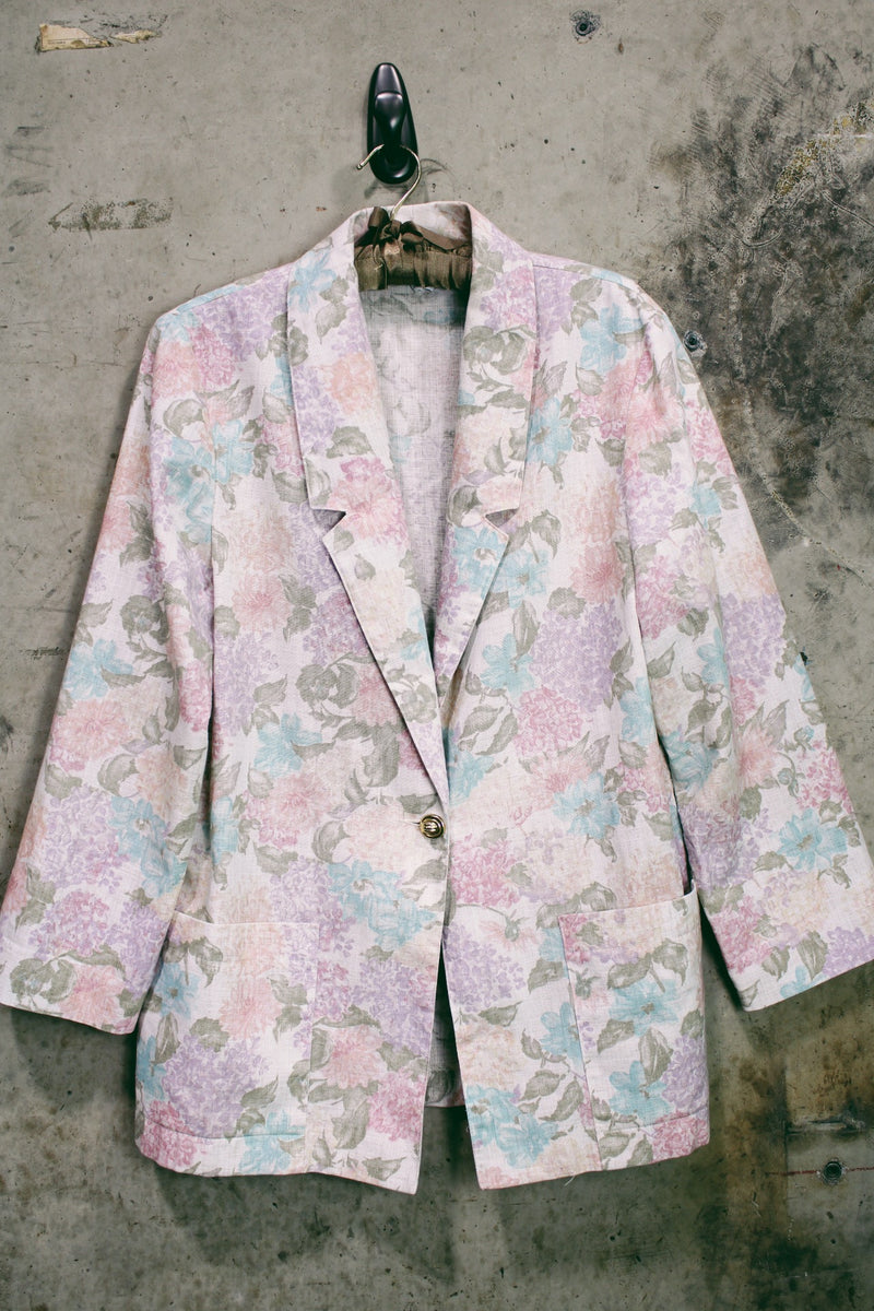 Women's vintage 1980's Sag Harbor label long sleeve lightweight floral print blazer with one gold button closure. White with pink and blue flowers.