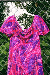 Women's vintage 1970's Penneys Hawaii label short sleeve maxi length dress with an all over pink and purple Hawaiian print.