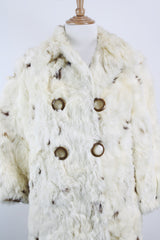 Women's vintage 1960's long sleeve genuine fur pea coat with a double breasted closure. Cream colored with all over brown speckles.