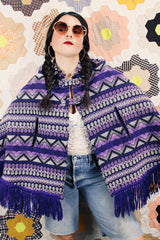 Women's vintage 1970's Made in Guatemala label purple and white printed poncho with fringe trim and two button closure across chest.