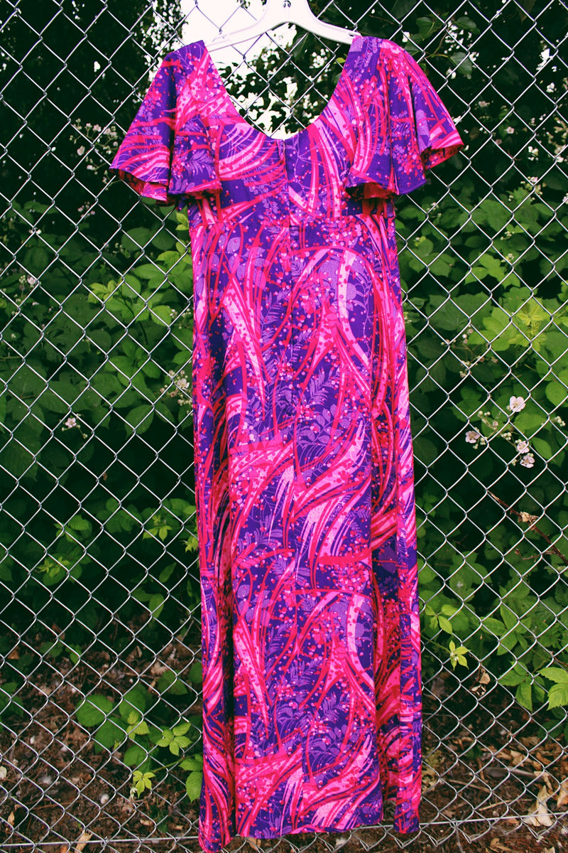 Women's vintage 1970's Penneys Hawaii label short sleeve maxi length dress with an all over pink and purple Hawaiian print.