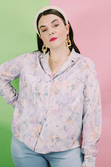 Women's vintage 1970's long sleeve button up blouse in an all over purple, blue, and pink floral print. Two chest pockets.