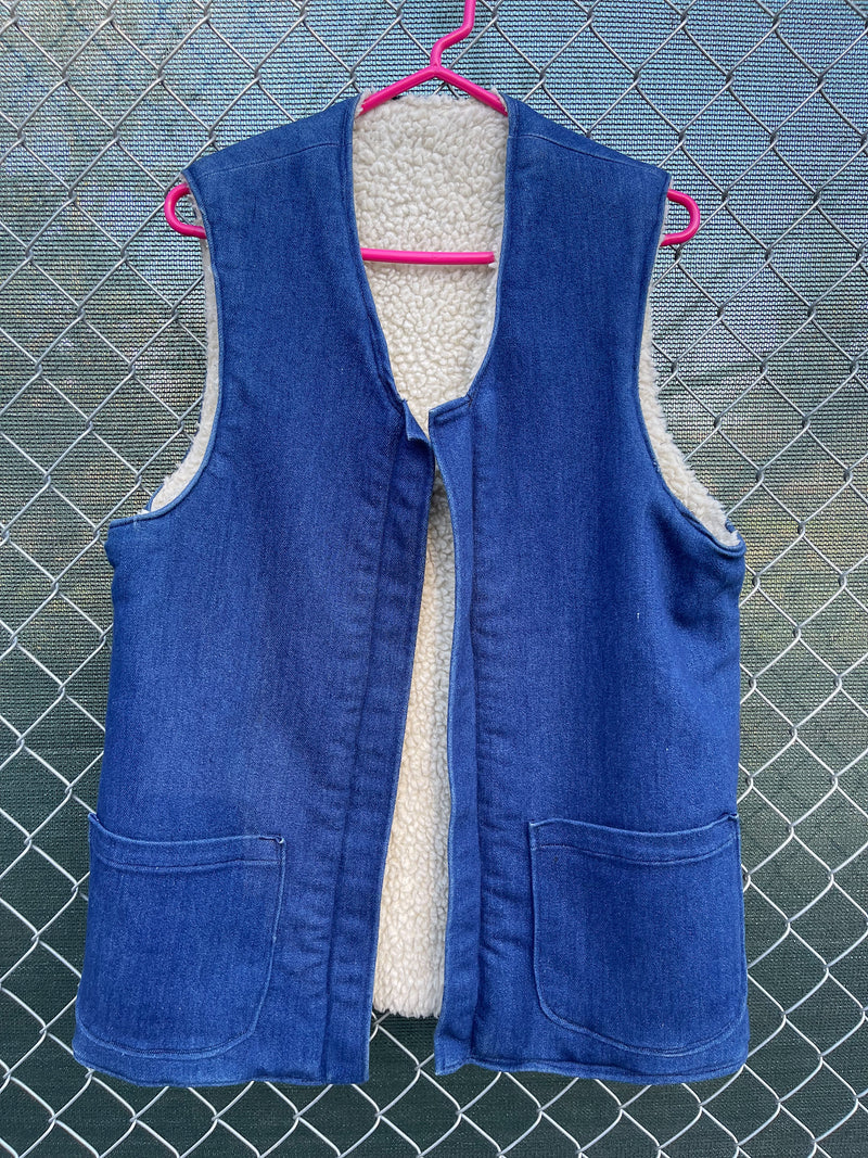 Men's or women's vintage 1970's sleeveless blue denim open front vest with cream shearling liner and pockets. 