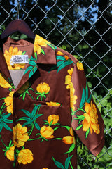 Men's vintage 1980's Hilo Hatties Hawaii label short sleeve button up floral print Hawaiian shirt in silky polyester material. Brown with all over yellow flowers.
