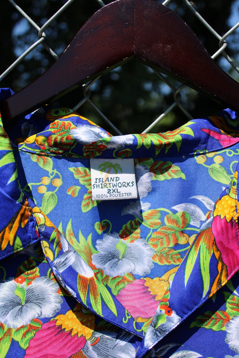 Men's vintage 1990's Island Shirtworks label short sleeve button up Hawaiian print shirt in blue with all over parrot print in a lightweight Polyester material. 