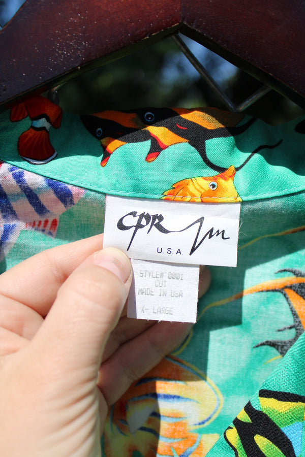 Men's vintage 1980's CPR ZIN, USA label short sleeve button up Hawaiian print shirt in turquoise with an all over fish print in a cotton material. 