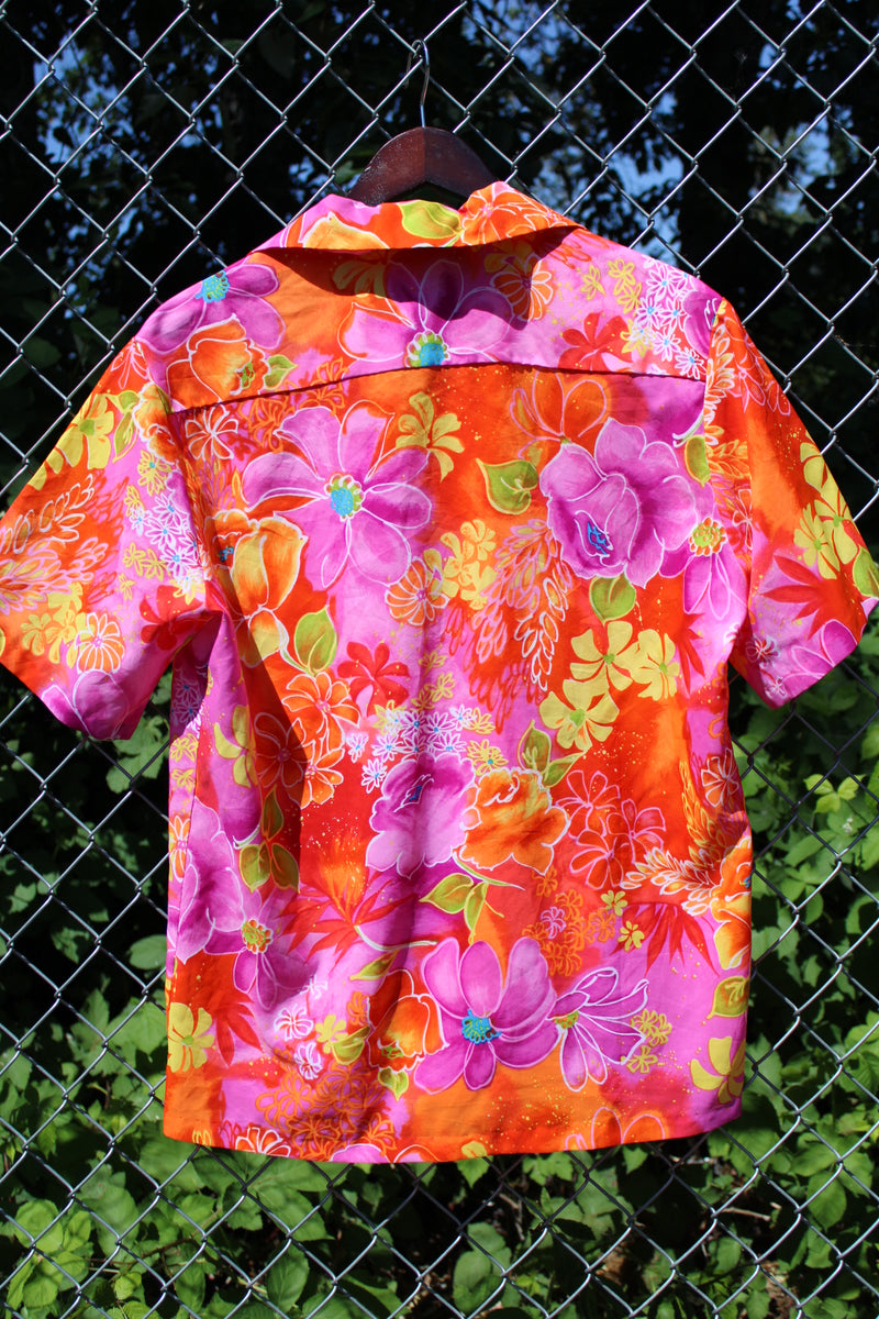 Men's or women's vintage 1970's Reef, Made in Hawaii label short sleeve button up Hawaiian print shirt in polyester material. Bright pink, orange, and yellow colors.