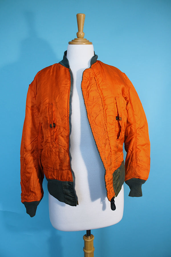 Women's or men's vintage army bomber jacket. Cropped and reversible in a Nylon material. One side is army green and one side in orange.