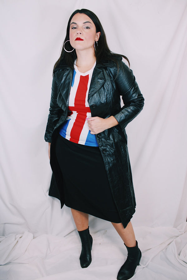 Women's vintage 1970's knee length long sleeve black leather trench coat with double lapel and button front closure. 