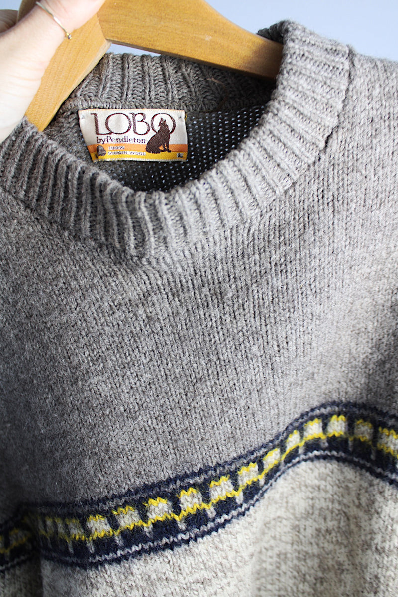 Women's or men's vintage 1990's Lobo by Pendleton label long sleeve pullover wool sweater in dark and light grey colors with navy and yellow print pattern across chest. 