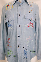 Men's or women's vintage 1970's BJ-R, Long Tail - Form Fit, Made in Hong Kong label long sleeve light blue denim chambray button up shirt with colored embroidery all over.