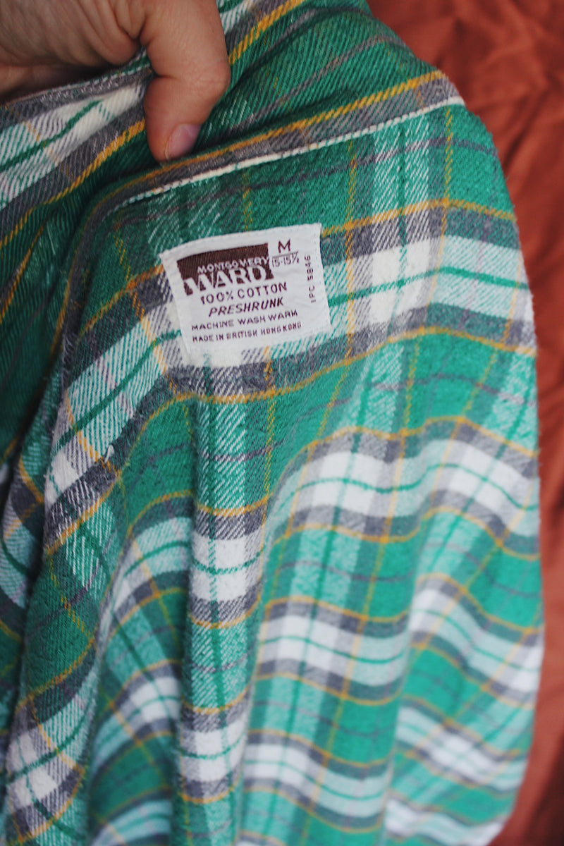 Women's or men's vintage 1970's Montgomery Ward label long sleeve button up flannel shirt in green and white plaid print. 