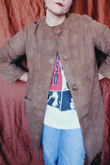 Women's vintage 1960's long length long sleeve tan brown colored suede jacket. No collar and suede buttons up the front.