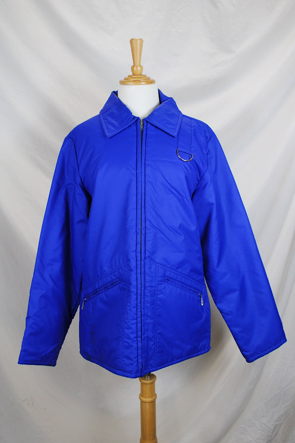 Men's or women's vintage 1980's Designer's Sportswear label long sleeve bright blue colored nylon material puffer jacket with side pockets.