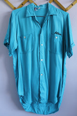 Men's or women's vintage 1970's The Swingster label short sleeve bright blue button up bowling shirt with chest pockets and name embroidered near pocket. 