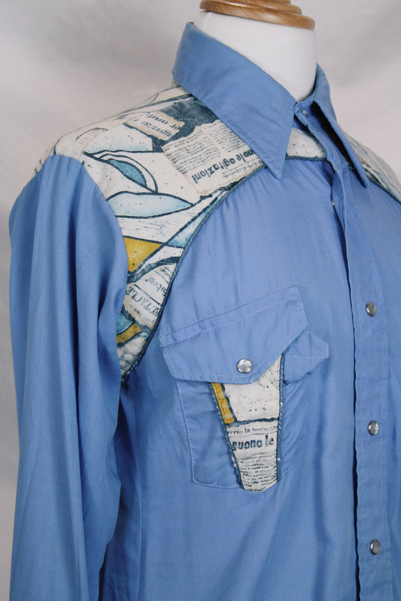 Men's vintage 1970's long sleeve button up blue colored shirt with patchwork detail throughout. Pearl snapper buttons up the front.