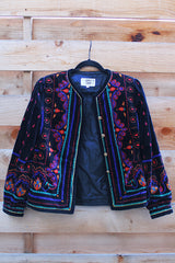 Women's vintage 1980's Saxton Hall, Made in Japan label long sleeve black velvet jacket with all over multicolored print and gold buttons.