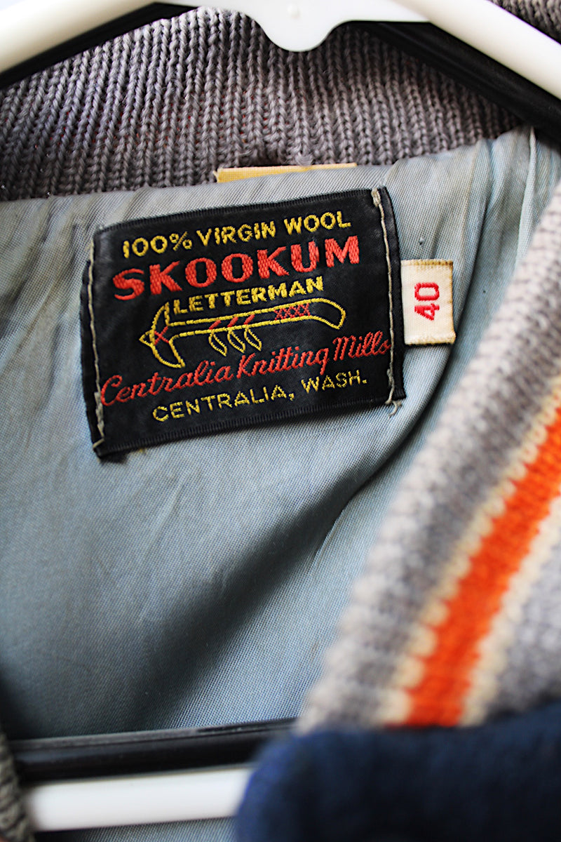 Men's vintage 1960's Skookum Letterman, Centralia Knitting Mills, Centralia Washington label long sleeve navy, white, and orange varsity letterman jacket in wool and leather material.