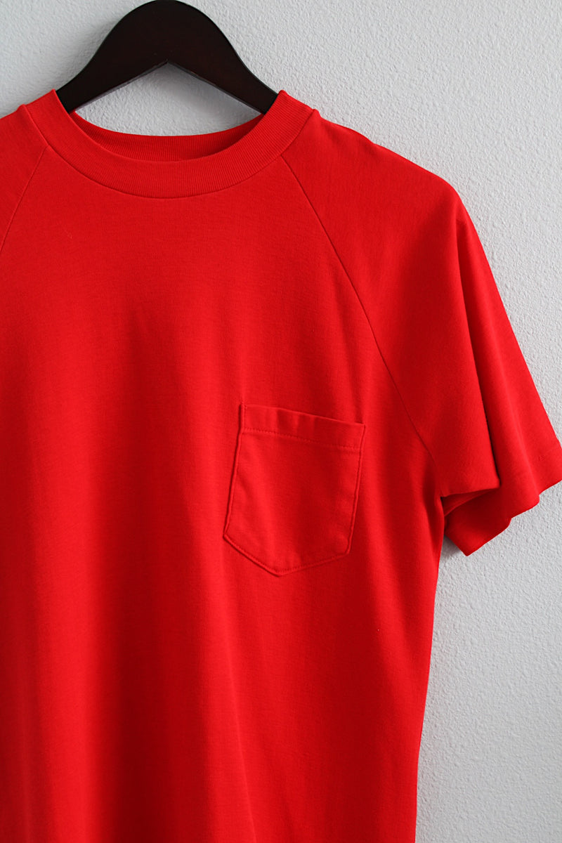 Men's or women's vintage 1980's short sleeve bright red t-shirt with one left chest pocket and a ribbed collar. 