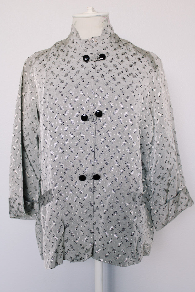 Women's vintage 1960's The Original Stork-A-Lure label long sleeve grey stain jacket with all over print. Black buttons up the front and mandarin collar.