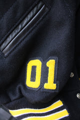 Men's or women's vintage 2000's Settlemein's, Portland, Oregon label long sleeve black varsity letterman jacket with yellow trim.
