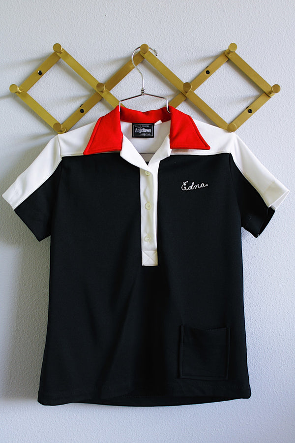 Women's vintage 1980's Donna Adamek Designs Angeltown California, Made in USA label short sleeve half button closure polo top with collar in red, black, and white polyester material.