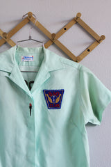 Women's vintage 1960's Hilton, Made in USA label short sleeve teal colored cotton button up blouse with collar and front pocket.