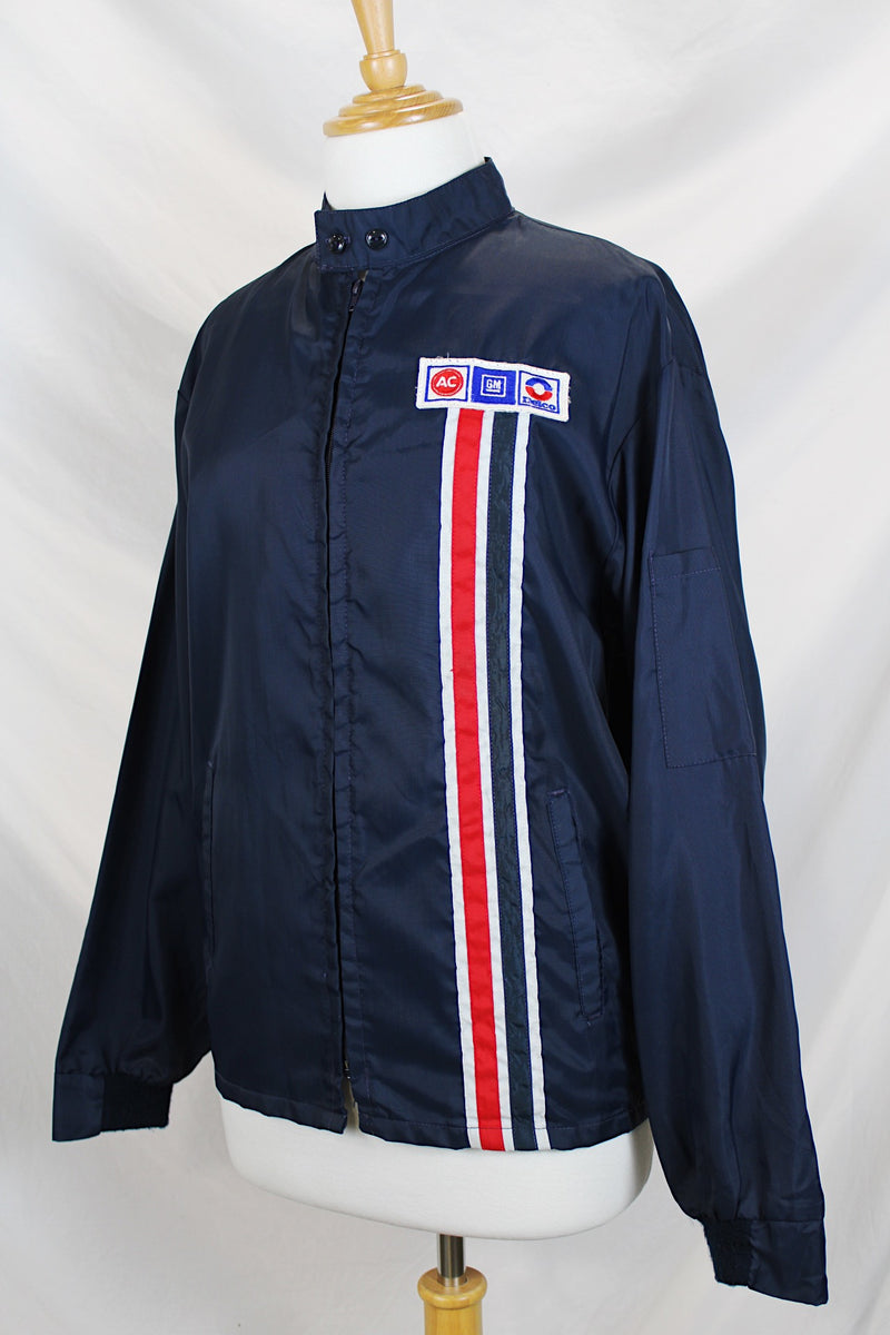 Men's or women's vintage 1980's Horizon Sportswear Inc., Made in USA label long sleeve navy blue nylon zip up windbreaker jacket with red and white vertical stripe down the front and patches.