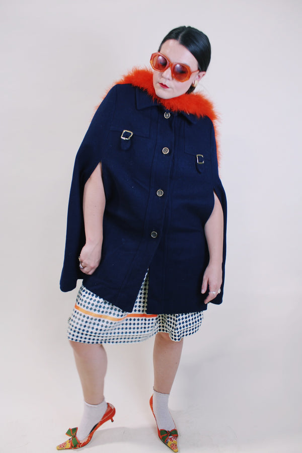 Women's vintage 1960's navy blue wool material poncho with slits for arms, gold hardware and gold buttons. Fully lined.
