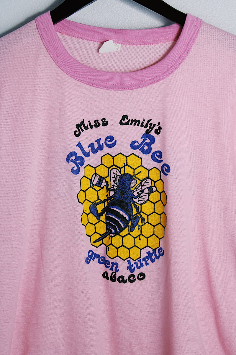 Women's vintage 1970's Chippie, Made in Bahamas label short sleeve bubblegum pink tee with a yellow and blue bee graphic on the front with a contrast trim. 