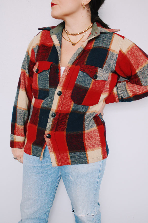 Men's or women's vintage 1960's Woolrich, Made in USA label long sleeve button up wool shacket in all over navy and red plaid print. Patch on arm.