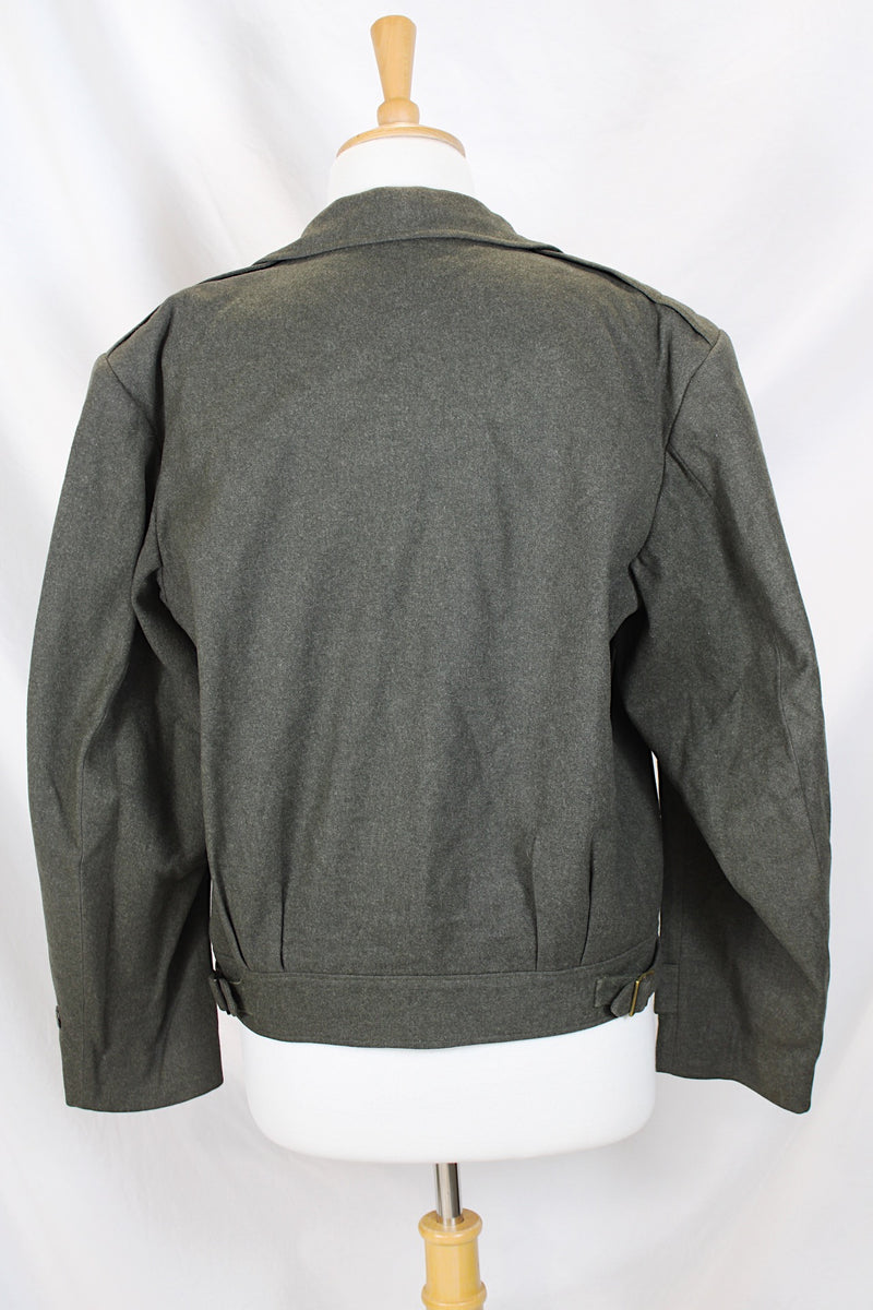 Women's or men's vintage cropped army jacket in a dark green grey wool material. Has a button closure and two front chest pockets. 