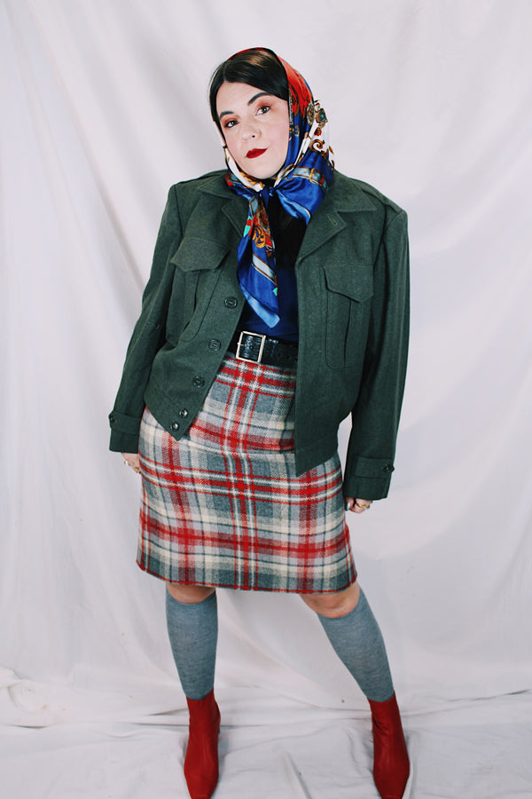 Women's or men's vintage cropped army jacket in a dark green grey wool material. Has a button closure and two front chest pockets. 