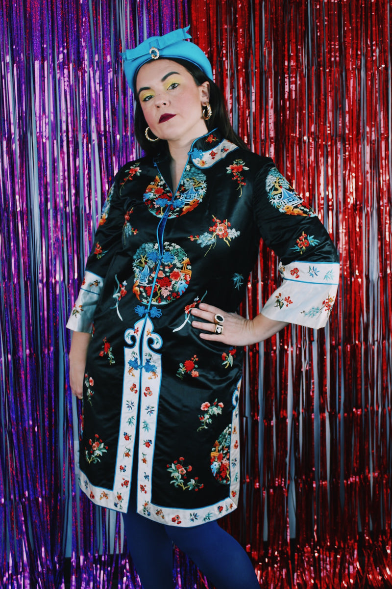 Women's vintage 1970's Bai Hua, Made in China label 3/4 arm length mid length lightweight robe jacket in black, white, blue, and an all over floral embroidered print.