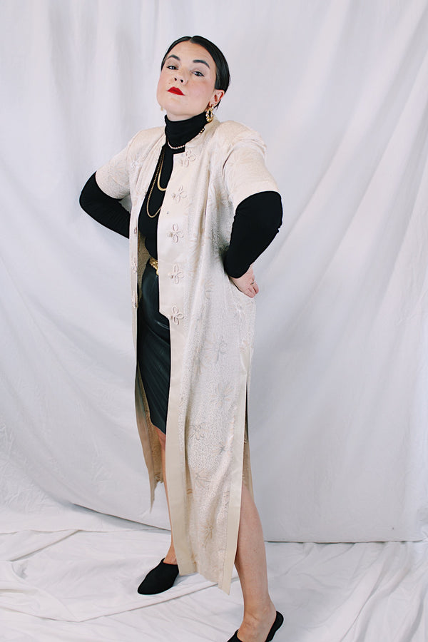 Women's vintage 1990's R & M Richards by Karen Wong label short sleeve long length duster dress in a cream satin like material. Long side slits, mandarin collar, and fabric covered buttons.