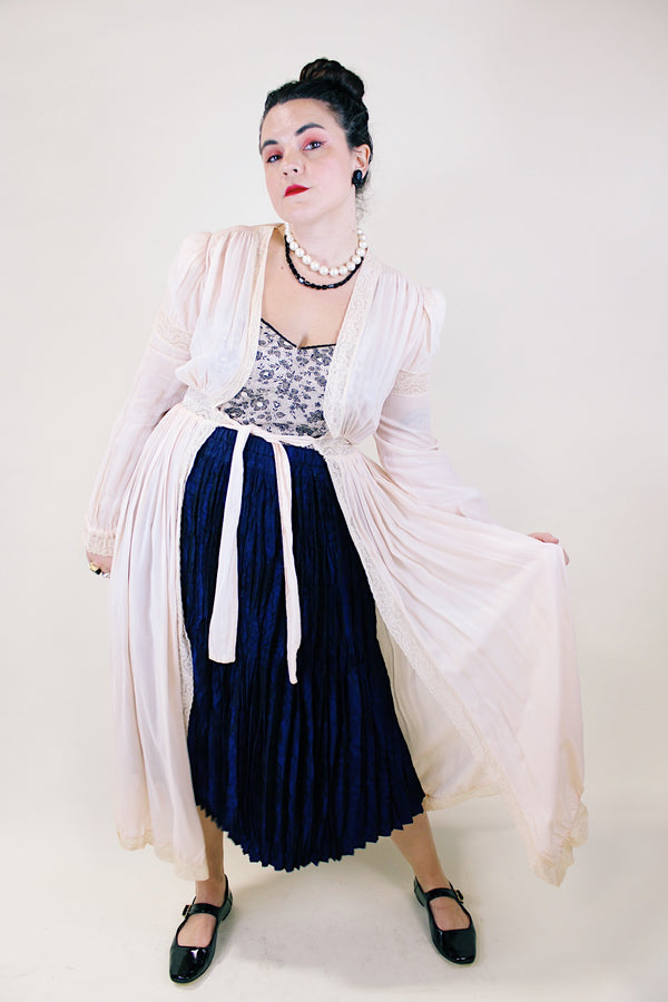 Women's vintage long sleeve long length pale pink sheer robe with an open tie front and lace trim. Has small shoulder pads and ties on cuffs. 