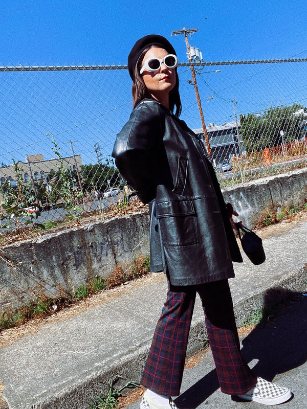 long sleeve black long leather jacket, collar and buttons up the front vintage 1960's